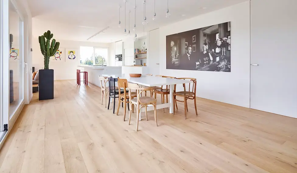 "Living room with a view of the dining table and kitchen featuring beautiful San Diego hardwood flooring by Legno Hardwood."